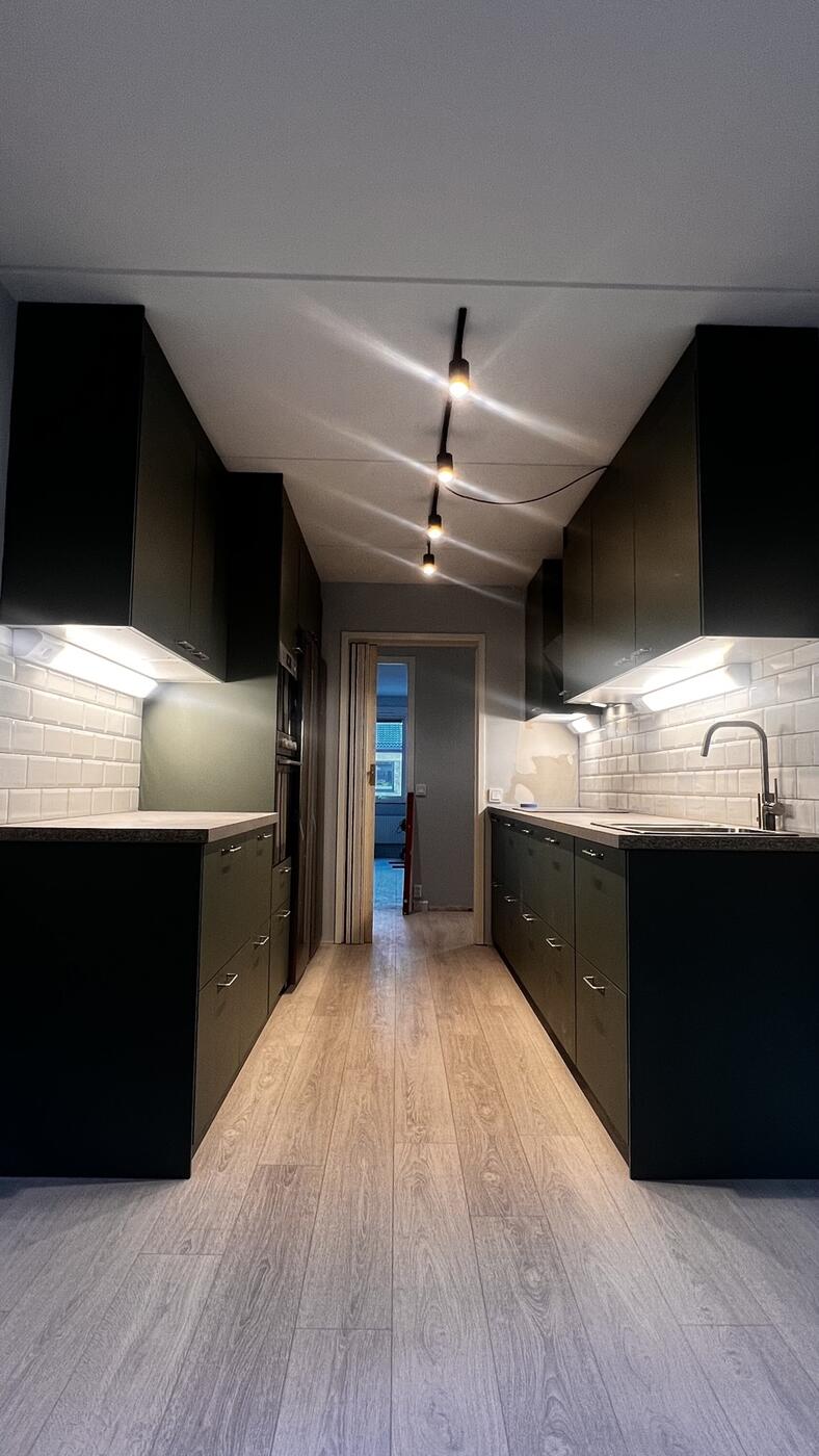 Samma kök i Nöbbelöv efter renovering, modernt mattsvart kök med vitt kakel