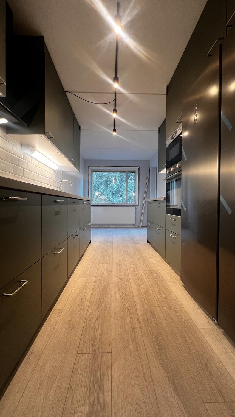 Samma kök i Nöbbelöv efter renovering, modernt mattsvart kök med vitt kakel