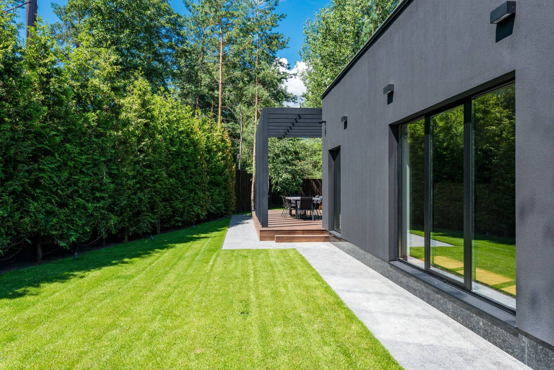 Modern husexteriör med tillbyggnad och trädgård